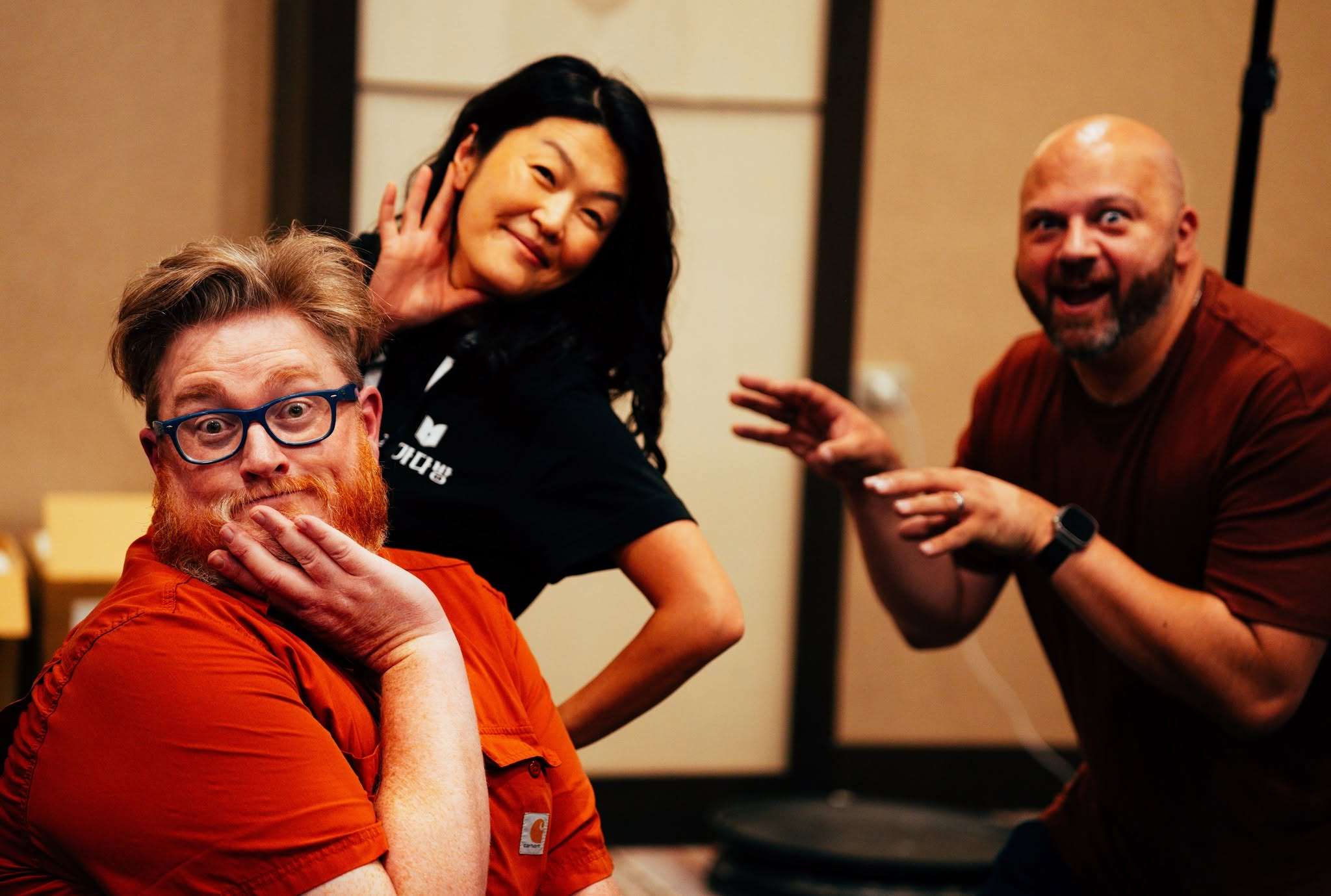 Three people, smiling goofily and posing at the camera.